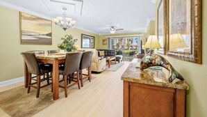 A spacious living area with a dining table, sofas, and a view of the outdoors.