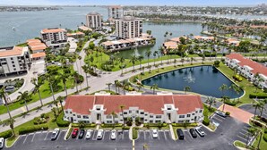 A hotel with a central courtyard, parking, and views of a body of water and cityscape.