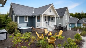 A house with a covered patio, outdoor seating, and a hot tub. - Seabrook SeaDragon | Pet Friendly, Hot Tub, 3BR | Sleeps 9, Sunrise Pool (Pacific Beach)