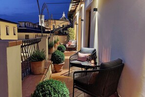 A narrow outdoor balcony with potted plants, a chair, and a table with wine glasses. - Charming wraparound balcony, perfect location in Florence (Florence)