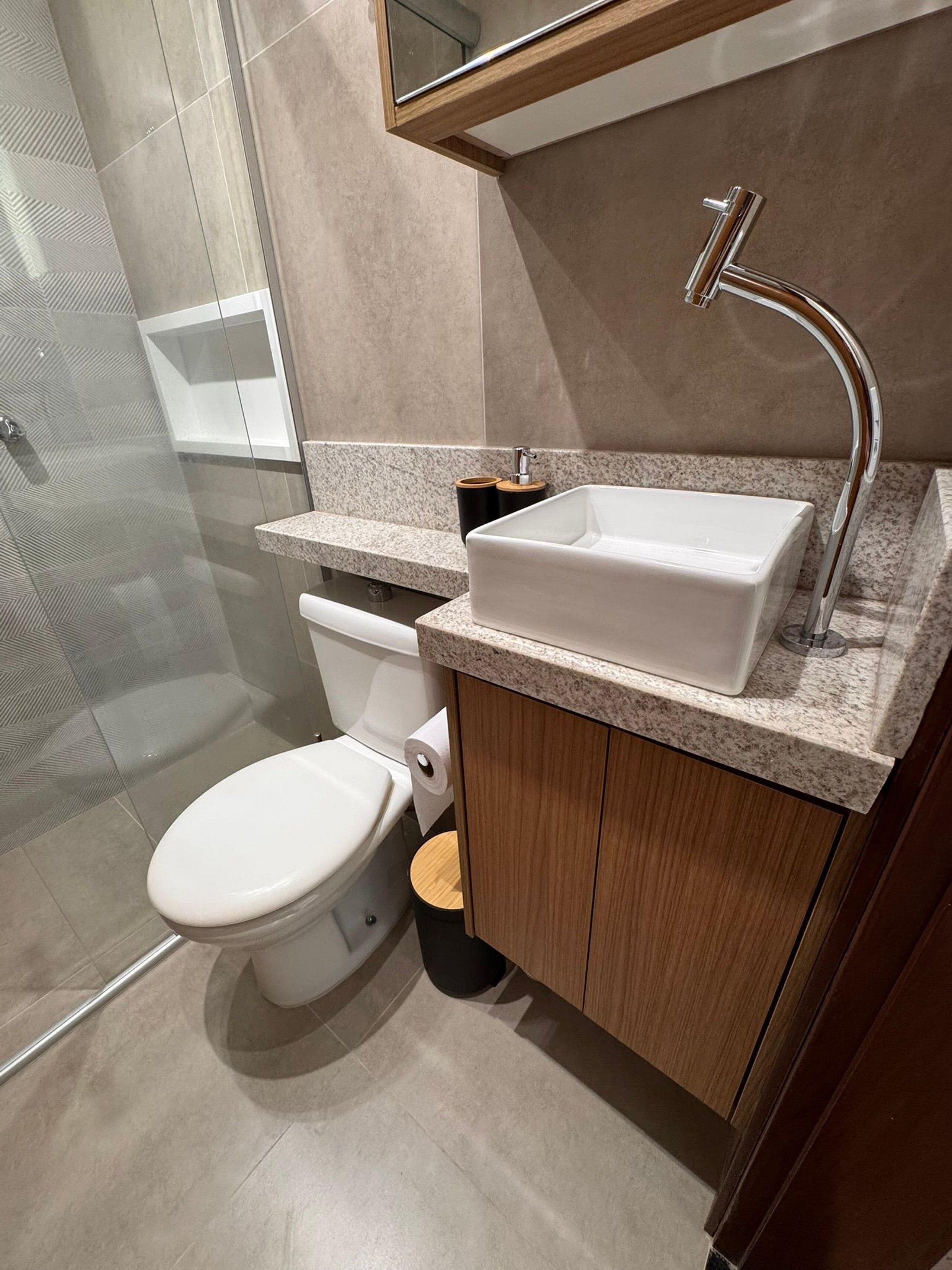 Une salle de bain moderne équipée de toilettes, d’un lavabo et d’une douche.