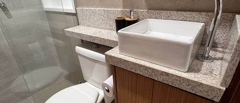Un baño moderno con inodoro, lavamanos y ducha.