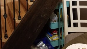 Un escalier en bois avec des balustrades noires et une main courante en bois foncé.