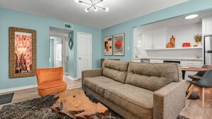 A modern living room with a sofa, armchair, and a wooden coffee table. - Bauhaus-1st Floor, King Beds, Walk to A&M Campus (Bryan)