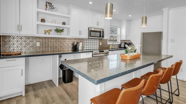 A modern kitchen with white cabinetry, a granite countertop, and a stainless steel refrigerator. - BethyKay: 2 Bedroom, Walk to A&M, Comfy King Beds (Bryan)