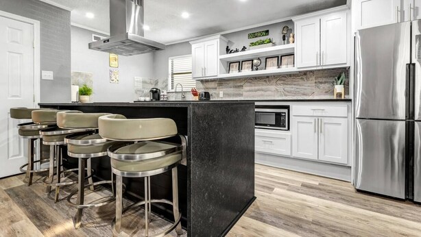 A modern kitchen with a central island, bar stools, stainless steel appliances, and white cabinetry. - Big Easy: 2 Bedrooms, 2nd floor, Walk to A&M, Comfy King Beds (Bryan)