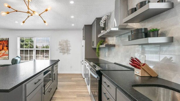 A modern kitchen with a central island, stainless steel appliances, and a decorative light fixture. - Cinema: 2 Bedroom, Walk to A&M, Comfy King Beds (Bryan)