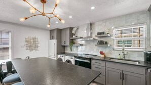 A modern kitchen with a central island, built-in appliances, and a pendant light fixture. - Cinema: 2 Bedroom, Walk to A&M, Comfy King Beds (Bryan)