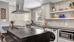 Een moderne keuken met een groot eiland, inbouwapparatuur en een strak, minimalistisch design.