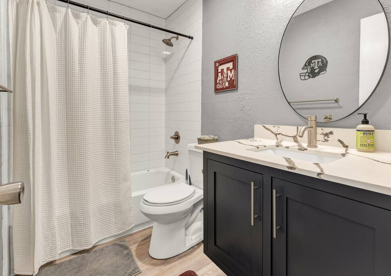 A modern bathroom with a shower, toilet, and vanity.