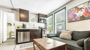 A compact living space with a kitchenette, a dining area, and a seating area with a couch and a table. - Tribeca: So Fun! Walk to A&M, Comfy King Beds (Bryan)
