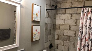 A bathroom with a marble sink, a toilet, a bathtub, and a shower curtain. - Wildflower: Very Near Texas A&M-Comfy King Beds (Bryan)
