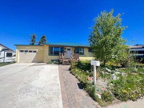 A single-story house with a garage, a front porch, and a driveway leading to the entrance.