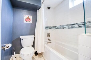Un baño con inodoro, ducha y bañera.