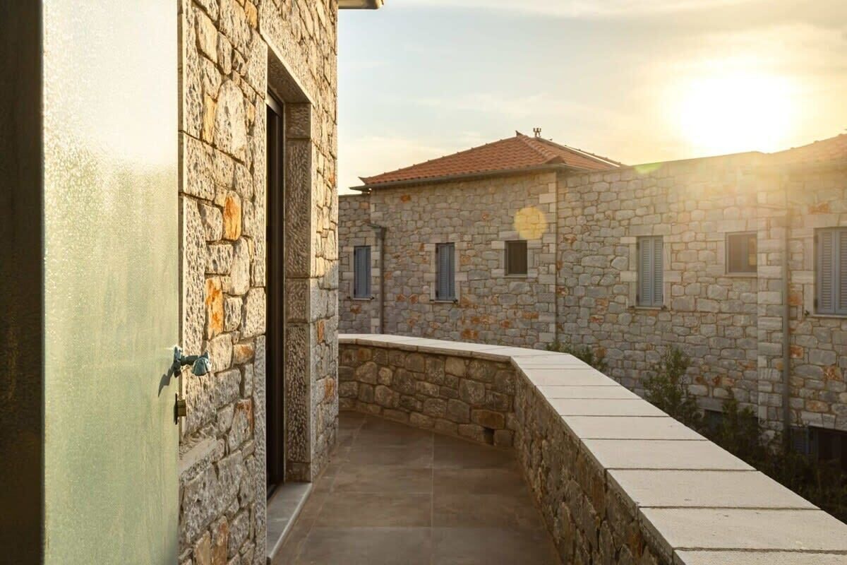 A stone building with a tiled roof and a small balcony.