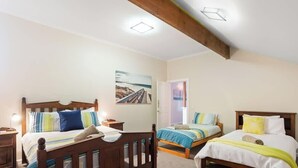Ein Schlafzimmer mit zwei Betten, Holz-Kopfteilen, Nachttischen und einem Bild an der Wand.