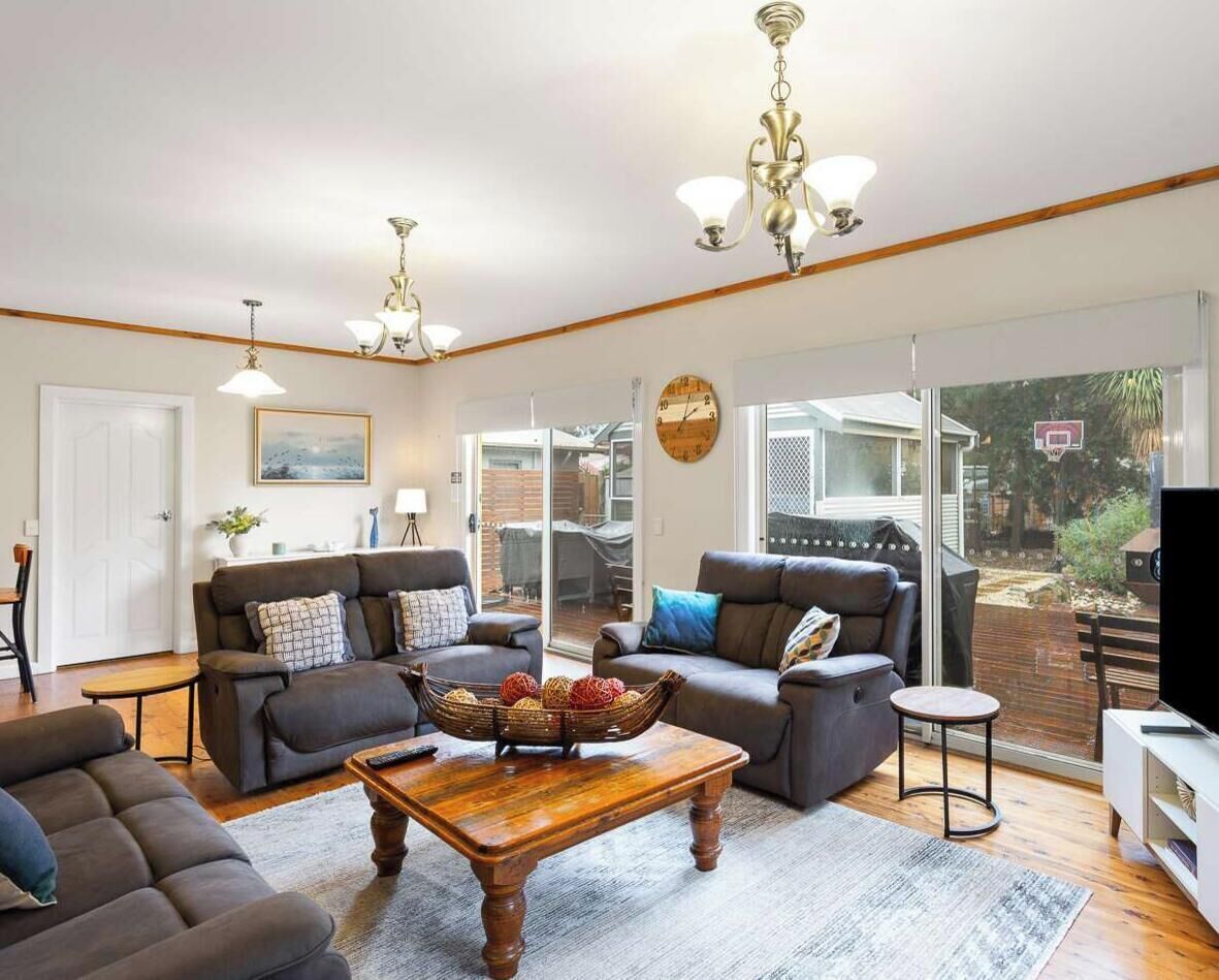 A spacious living room with a fireplace, a large window, and a television.