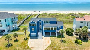 A coastal property with a large house, a pier, and a beach view. - Beachfront Beauty w/ 5 Decks, Private Walkover, Spacious Living Area & Elevator! (Galveston)
