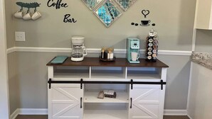 Un espacio de cafetería con una máquina de café, un preparador de café y una exhibición de tazas.