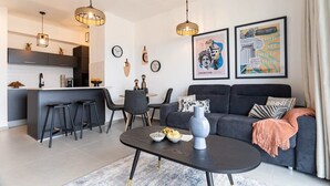 Una sala de estar moderna con sofá, mesa de centro y una obra de arte en la pared.