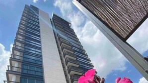 Un moderno edificio de gran altura con un diseño escalonado característico, con balcones y ventanas amplias.