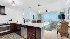 A modern kitchen with a large island, dark wooden cabinets, stainless steel appliances, and pendant lighting. - 🏖️XL Balcony with Awesome View - 2BR Boardwalk 209C🏖️ (Panama City Beach)