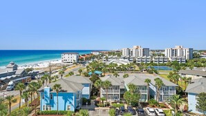 Ein Küstenwohngebiet mit Strandhäusern, einer Straße und freiem Blick auf das Meer.