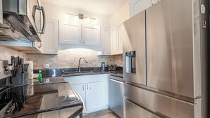 Una cocina moderna con electrodomésticos de acero inoxidable, horno integrado y un lavamanos.