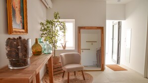 A room with a wooden table, a chair, a large mirror, and a potted plant. - Le Toit Penché (Tardinghen)