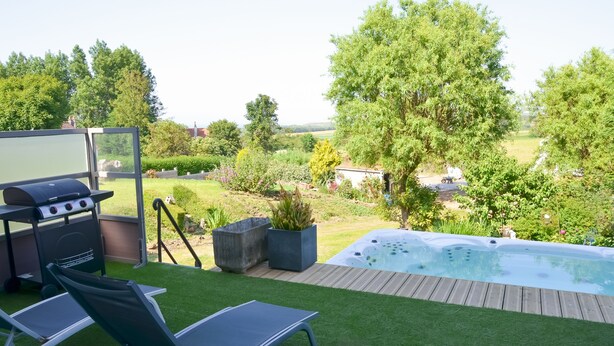 A backyard with a hot tub, a grill, and a pool. - Le Toit Penché (Tardinghen)
