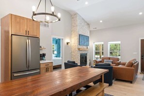 A modern kitchen with a large refrigerator, wooden cabinets, and a stone accent wall.