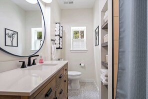 A bathroom with a large mirror, a toilet, a sink, and a towel rack. - Relax at Newly Constructed home in Egg Harbor (Egg Harbor)