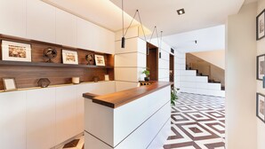 A modern kitchen with a wooden countertop and white cabinetry. There is a staircase leading to another level. - Gargiulo Resort (Sant'Agnello)