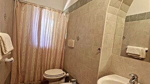 A bathroom with a toilet, bidet, and sink, tiled floor, and a shower curtain. - Case Vacanze Le Buganville (Forio)