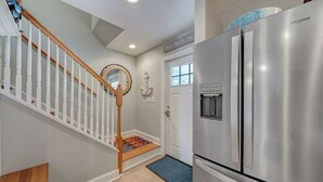 Una cocina moderna con un refrigerador de acero inoxidable y una escalera de madera.