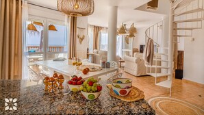Un salón amplio con una gran mesa de comedor, un sofá y una escalera.