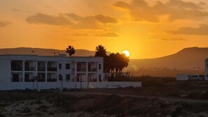 A white building with balconies and a palm tree in front. - Casa Fin del Mundo El Cotillo (El Cotillo)