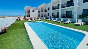 A modern hotel with a pool, multiple balconies, and a view of the beach. - Casa Fin del Mundo El Cotillo (El Cotillo)
