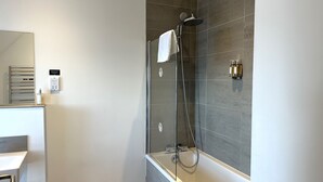 A modern bathroom with a glass-enclosed shower, a white towel hanging on the wall, and a built-in sink. - Northstar 2 (Wick)