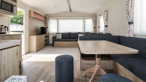 Un intérieur de camping-car moderne comprenant une cuisine, un coin repas et un espace salon.