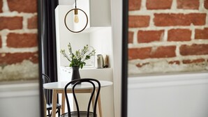 Un comedor con una mesa blanca, sillas negras, una planta en maceta y una lámpara colgante.