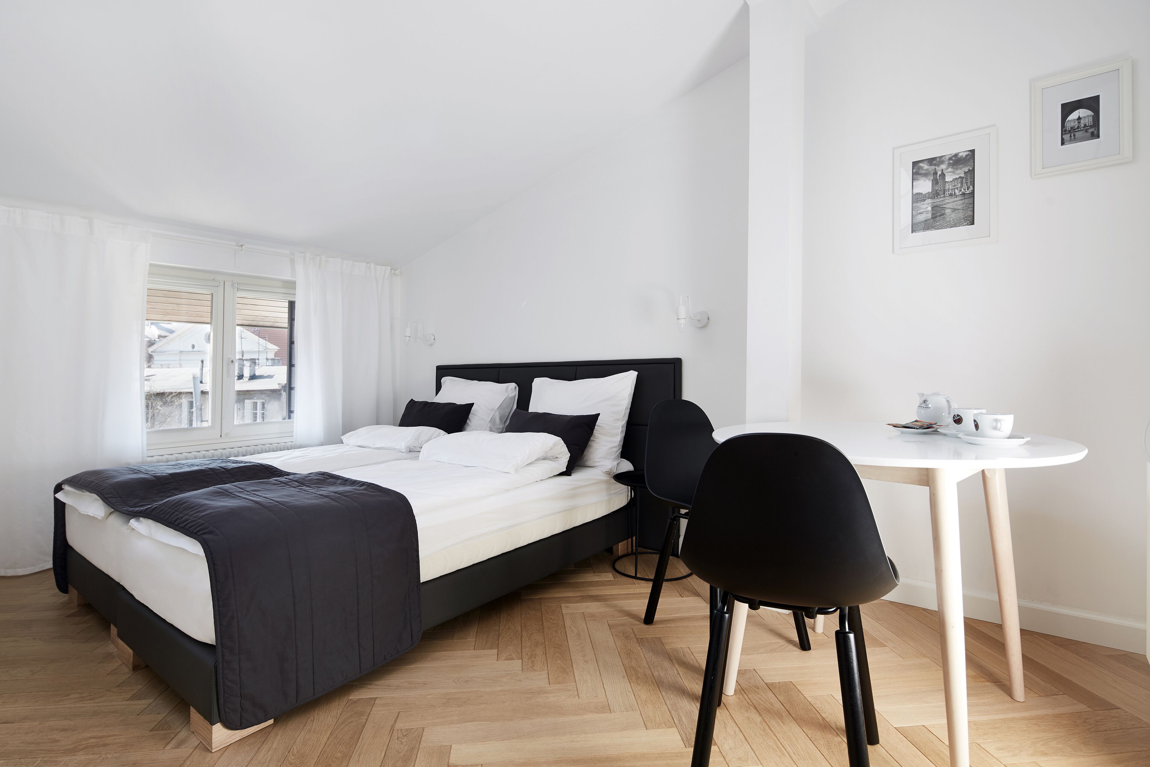 A modern bedroom with a bed, a desk, and chairs.