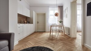 Una cocina moderna con armarios blancos, encimera de madera y comedor con mesa y sillas.
