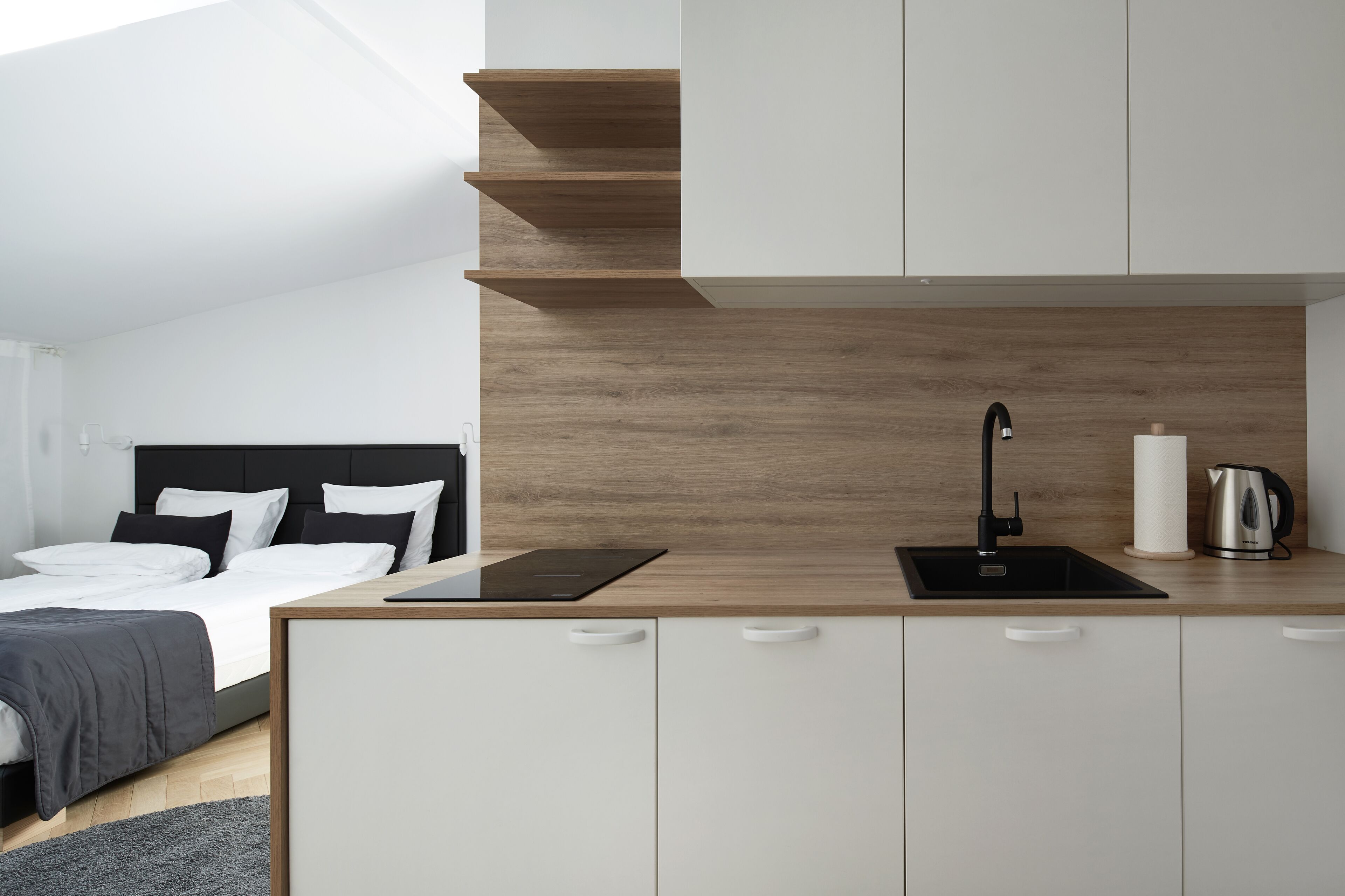 Un dormitorio moderno con cama, mesita de noche y velador.