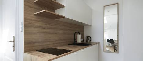 Eine moderne Küche mit Holzausstattung und einer schwarzen Arbeitsplatte.