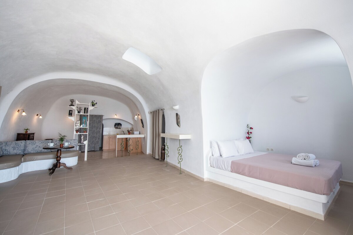 Ein geräumiges Zimmer mit einem großen Bett, einer Sitzecke und einer Küche.