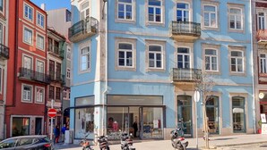 Un edificio de varios pisos con escaparate que dice "Typoraphia" y un letrero que indica "Hostel".