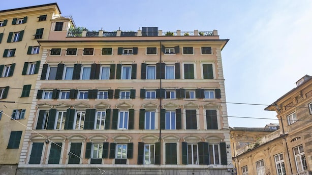 A multi-story building with a classical architectural style, featuring a symmetrical facade with evenly spaced windows and shutters. - Cairoli Stylish Apartment by Wonderful Italy (Genoa)