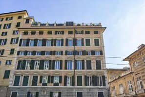 A multi-story building with a classical architectural style, featuring a symmetrical facade with evenly spaced windows and shutters.