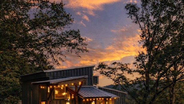 A rustic cabin with a fire pit and outdoor seating.